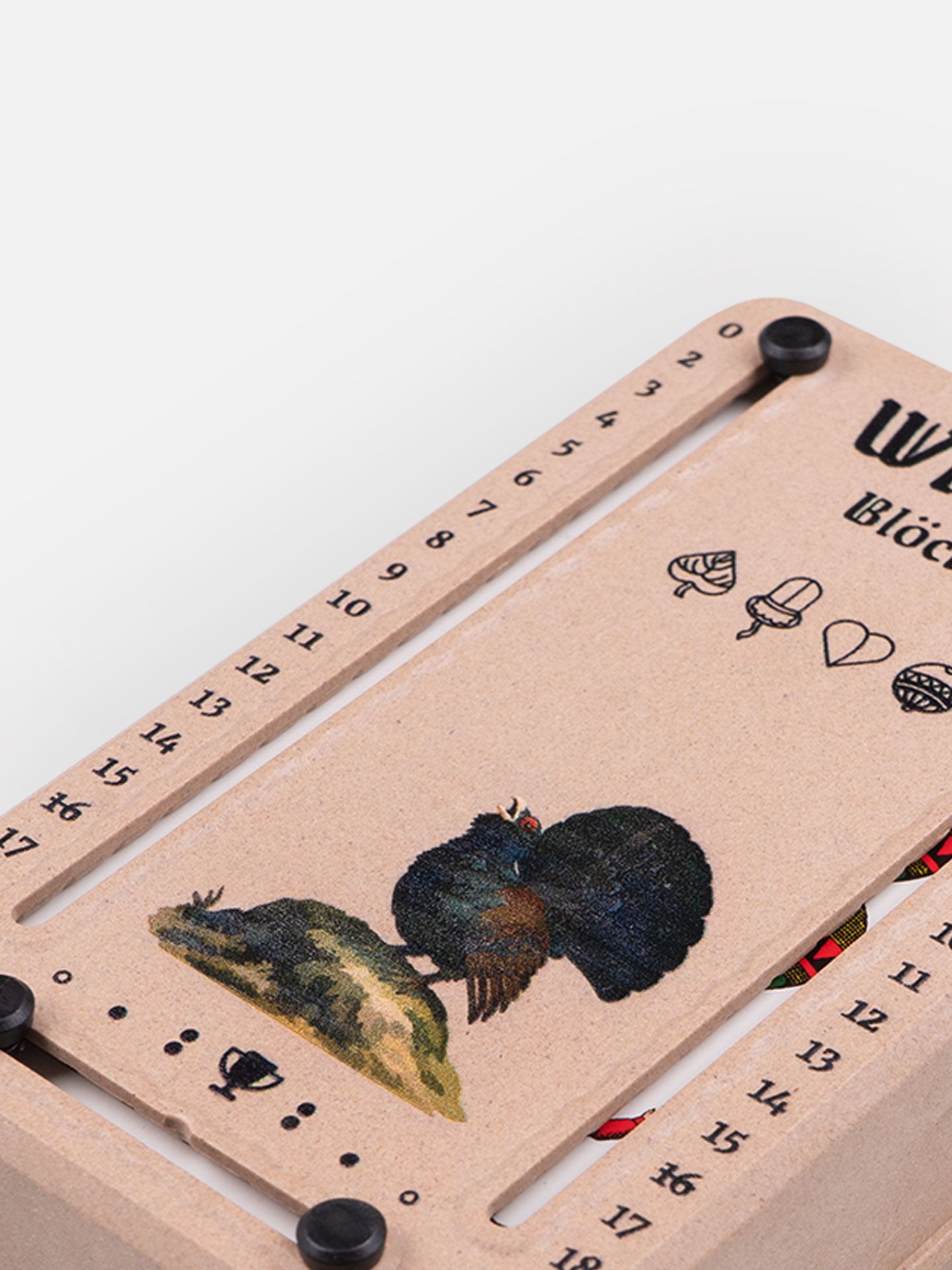 Detail Aufnahme Wattblöckl in Holzoptik mit Auerhuhn Motiv auf grauen Hintergrund.