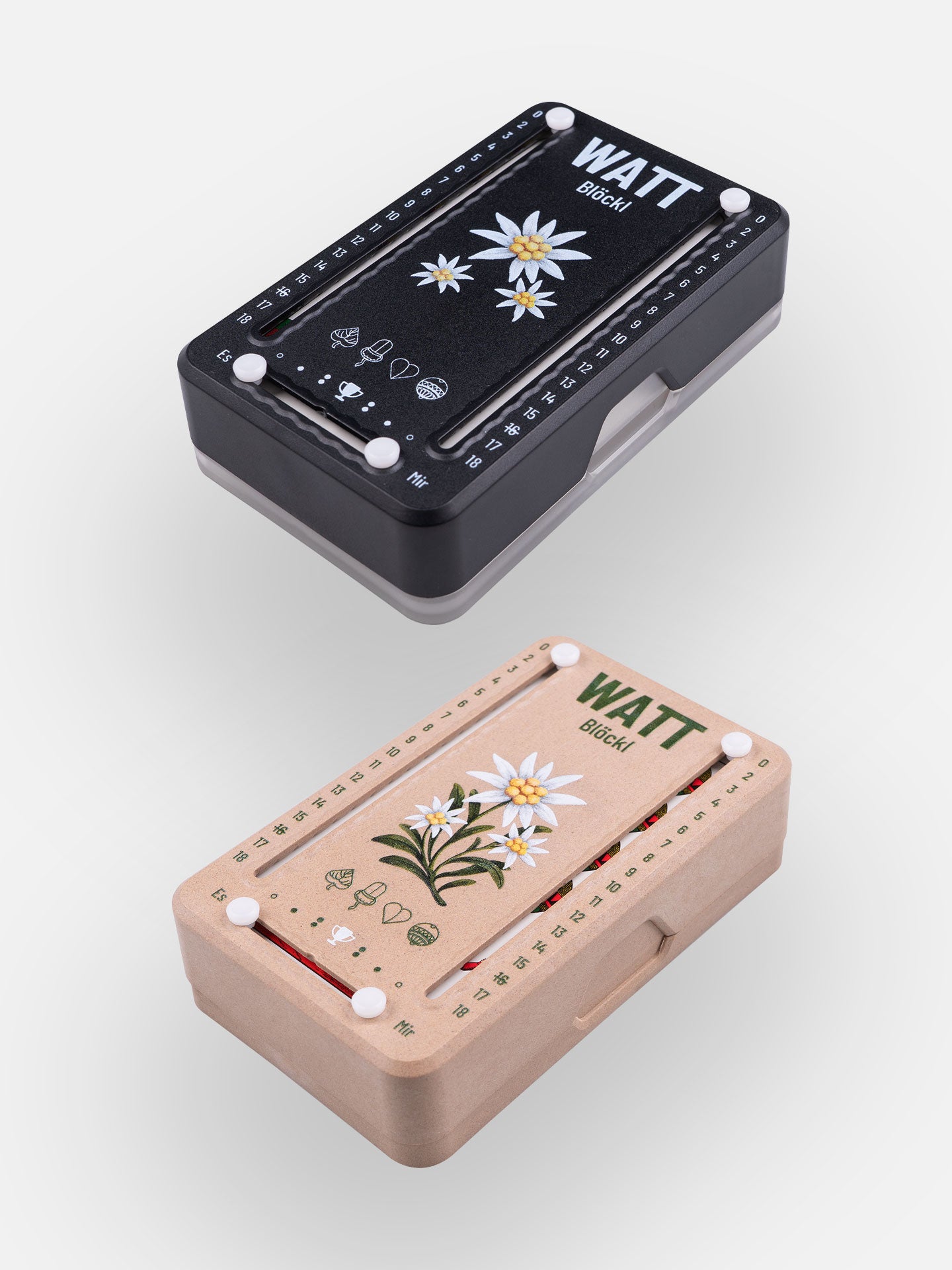 Zwei Wattblöckl (perspektivisch fotografiert) in Kunststoff schwarz und Holzoptik mit Motiv Edelweiß.