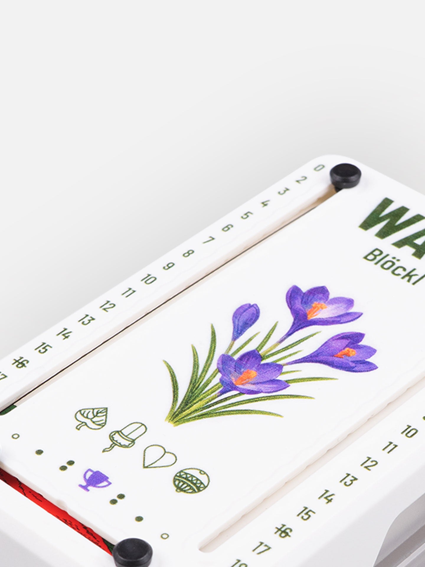 Detail Aufnahme Wattblöckl aus Kunststoff in weiß mit Krokus Motiv auf grauen Hintergrund.