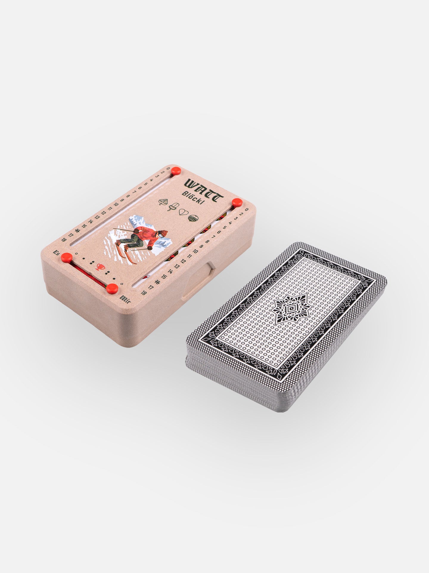 Wattblöckl in Holzoptik und roten Pins mit Skifahrer Motiv und Salzburger Spielkarten.