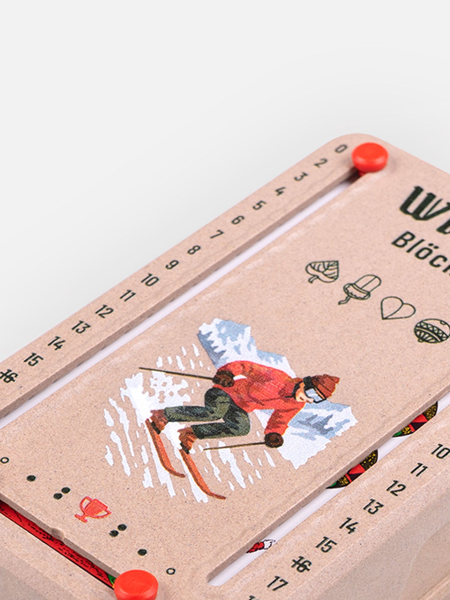 Detail Aufnahme Wattblöckl in Holzoptik mit Skifahrer Motiv auf grauen Hintergrund.