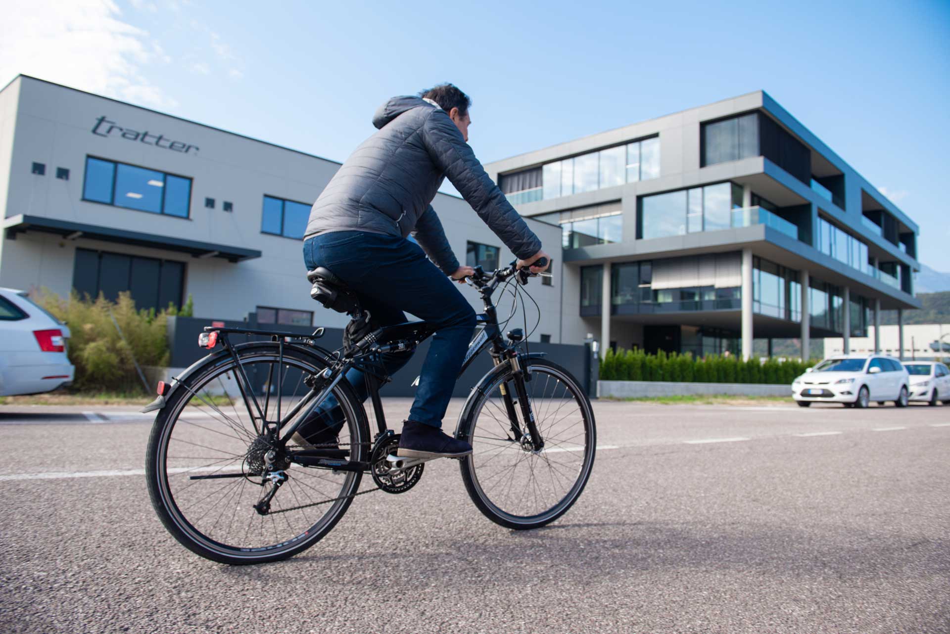 Radfahrer fährt an einem sonnigen Tag auf der Straße am Firmensitz vorbei.
